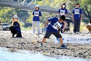 　「第２３回仁淀川国際水切り大会」で石を投げる参加者＝１１日午前、高知県いの町