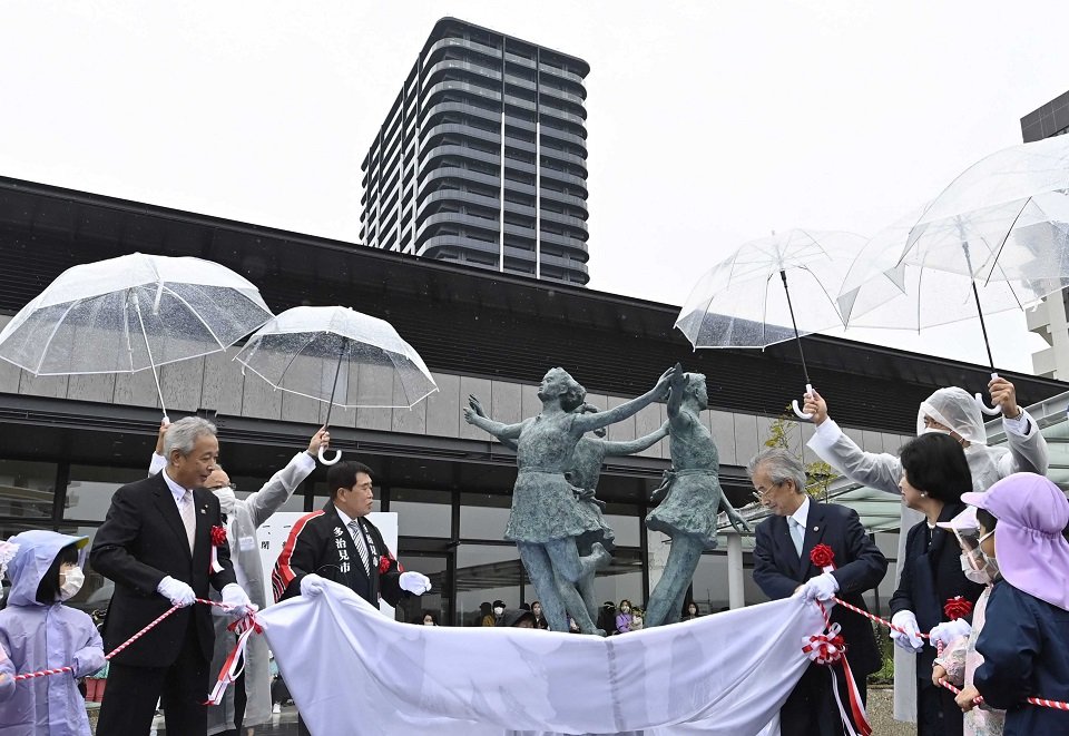 多治見駅南地区市街地再開発事業の完成を祝い除幕されたブロンズ像＝１日午前１０時７分、多治見本町
