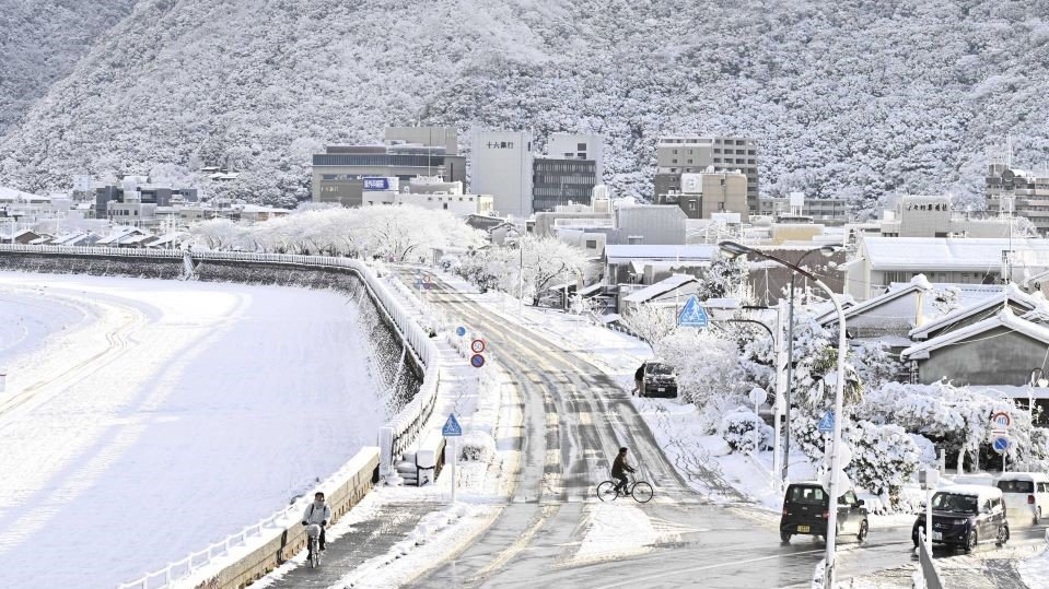 雪化粧した長良川堤。背景は金華山＝１４日午前８時２６分、岐阜市内