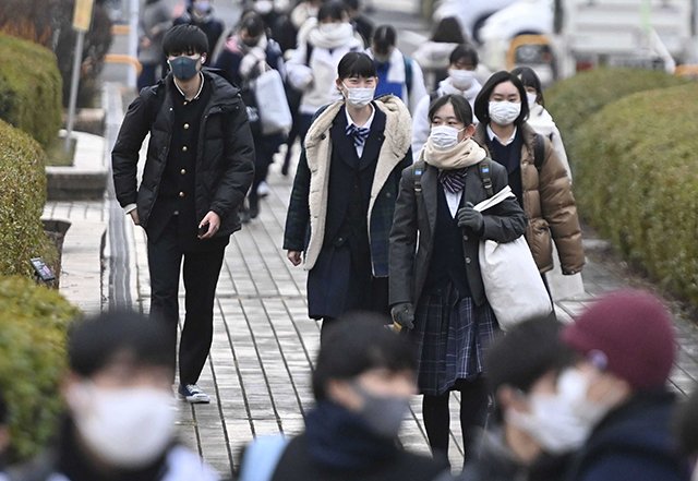 大学入学共通テストの初日、マスク姿で試験会場に向かう受験生ら＝１６日午前７時５２分、岐阜市柳戸、岐阜大