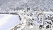 雪化粧した長良川堤。背景は金華山＝１４日午前８時２６分、岐阜市内