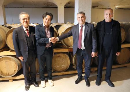 　握手を交わす、北海道余市町の斉藤啓輔町長（中央左）と、ジョージア東部グルジャーニ市の市長（同右）＝２８日、グルジャーニ（同市提供・共同）