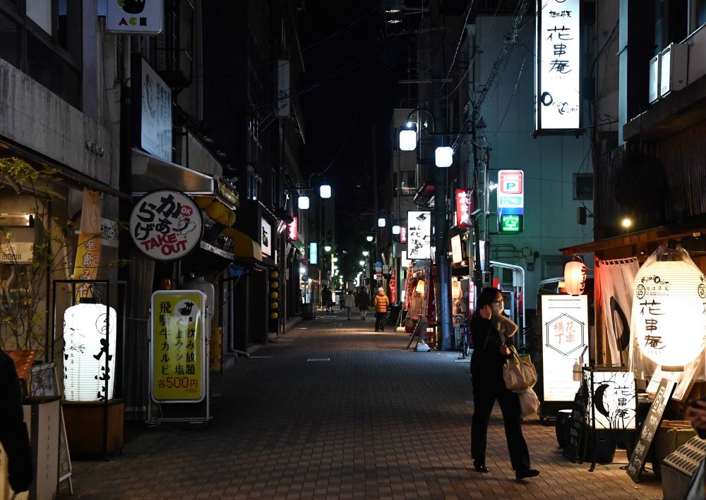 認証店で酒の提供が可能となった７日、営業再開と休業とで選択が分かれた玉宮通り。人影はまばらだった＝７日午後６時４７分、岐阜市住田町