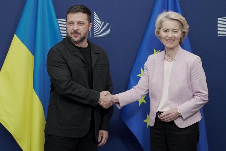 　１７日、ブリュッセルで握手するＥＵのフォンデアライエン欧州委員長（右）とウクライナのゼレンスキー大統領（ロイター＝共同）