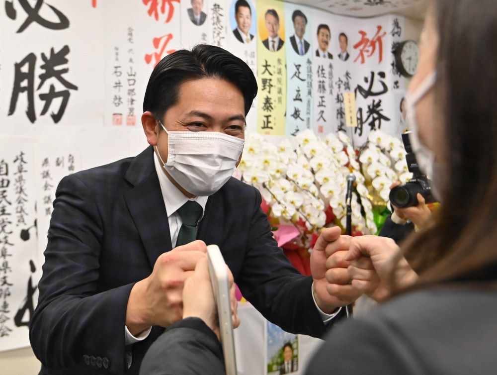 岐阜市長選で再選を確実にして支持者とグータッチを交わす柴橋正直さん＝６日午後８時半、岐阜市端詰町、選挙事務所