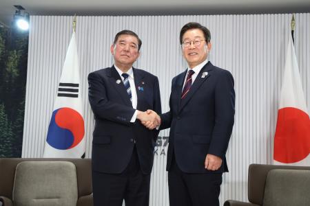 　会談を前に握手する石破首相（左）と韓国の李在明大統領＝１７日、カナダ西部カナナスキス（代表撮影・共同）
