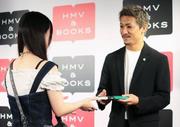 　イベントで集まったファンに自叙伝を手渡すサッカー日本代表の前田大然＝１０日午後、東京都渋谷区