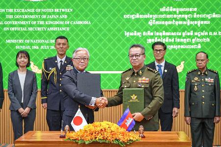 　カンボジアの首都プノンペンで開かれた署名式に出席する植野篤志駐カンボジア大使（手前左）とティア・セイハ副首相兼国防相（手前右）＝１９日（外務省提供）