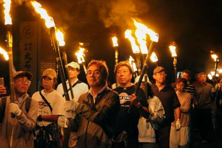 　「稲むらの火祭り」で、たいまつを手に歩く町民ら＝２４日夜、和歌山県広川町