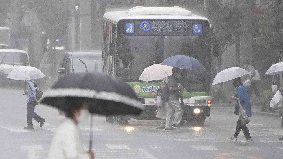 台風４号から変わった低気圧の接近で雨が強まる中、横断歩道を渡る人たち＝５日午前１０時５８分、岐阜市神田町