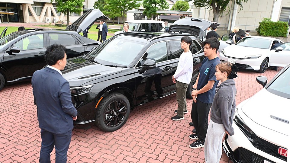 ホンダカーズ東海の社員から販売している車の説明を受ける学生たち＝岐阜市中鶉、岐阜聖徳学園大