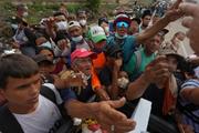 　ベネズエラ・ラグアイラで、物資を受け取ろうとする人たち＝６月３０日（ＡＰ＝共同）