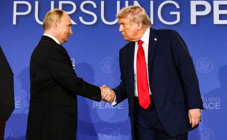 　共同記者発表後、握手するロシアのプーチン大統領（左）とトランプ米大統領＝１５日、米アラスカ州アンカレジ（ロイター＝共同）