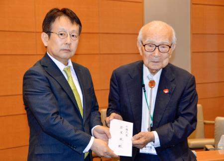 　外務省の中村仁威軍縮不拡散・科学部長（左）に要請書を手渡す被団協の田中熙巳代表委員＝２０日午後、東京都千代田区