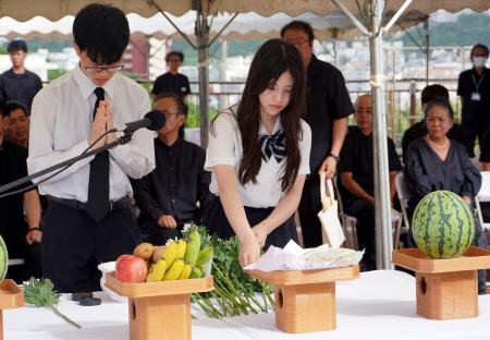 　旧海軍司令部壕で開かれた慰霊祭で献花する参列者＝１３日午後、沖縄県豊見城市