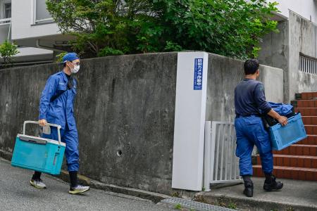 　大型冷凍庫から成人男性の遺体が見つかったマンションに出入りする捜査員＝２２日午前、神戸市中央区