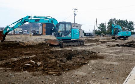 　朝市通り周辺でがれきを撤去する重機＝２６日午前、石川県輪島市