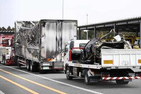 　事故があった新名神高速下り線の野登トンネルから運び出された焼けたトラックと車両（荷台上）＝３月２０日、三重県菰野町