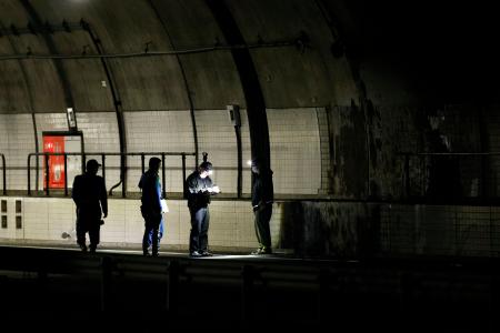 　新名神高速道路下り線の野登トンネル出口付近を調べる捜査員＝２４日夜、三重県亀山市