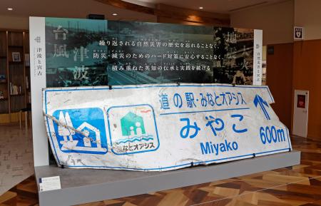 　「市災害資料伝承館」に展示されている東日本大震災の津波でねじまがった道の駅の案内標識＝岩手県宮古市
