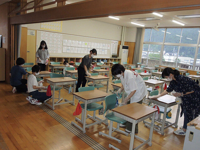 小学校の教室で消毒ボランティアに取り組む岐阜女子大生＝山県市高富、高富小学校