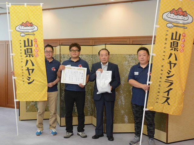 林宏優市長（右から２人目）に山県ハヤシライスを贈った「一國会山県ハヤシライス研究所」のメンバー＝山県市役所