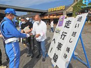 高速道路利用者にチラシを配布する吉田和浩県警高速隊長（左）＝各務原市川島笠田町、川島パーキングエリア