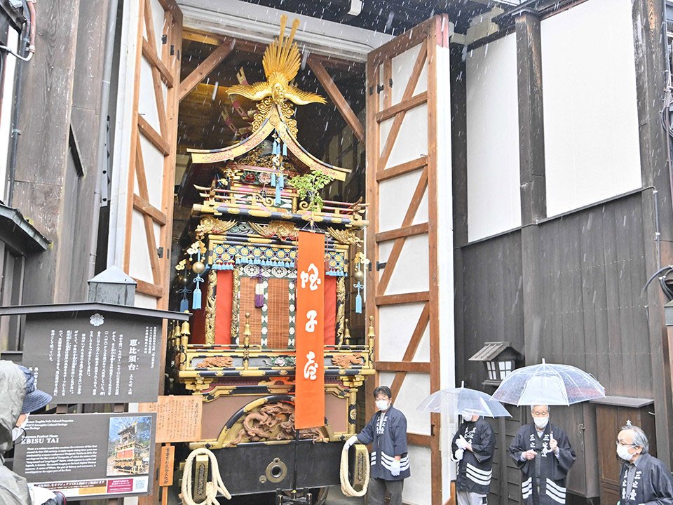 雨の中、蔵から姿を見せた祭り屋台＝１４日午前８時４３分、岐阜県高山市上三之町、恵比須台