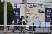 台風７号が接近する中、カートを引いて歩く人たち＝１５日午前８時１０分、岐阜市神田町