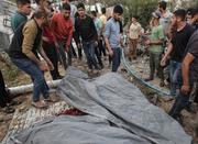 　パレスチナ自治区ガザで、イスラエル軍の攻撃による犠牲者の周りに集まる人々＝１８日（ゲッティ＝共同）