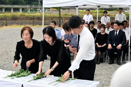 　豪雨災害から１７年となり、「復興ひろば」で献花する遺族＝９日午前、兵庫県佐用町