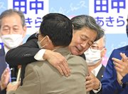高山市長選で初当選を果たし、駆けつけた國島芳明市長と抱き合う田中明さん＝２８日午後１１時４２分、高山市内