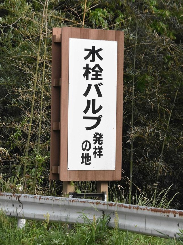 約３０年前に美山町が設置した「水栓バルブ発祥の地」とＰＲする看板＝山県市佐野