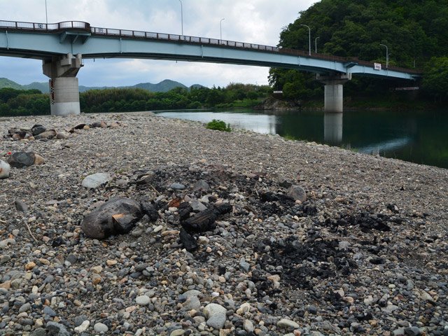 人けのない河原。バーベキューで使ったと思われる焼けた炭や焦げた石が残されていた＝１５日午前１１時２６分、岐阜市長良古津、長良川右岸