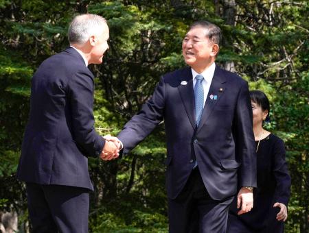 　Ｇ７サミット会場のカナダ西部カナナスキスで、カナダのカーニー首相（左）の出迎えを受ける石破首相＝１６日（共同）