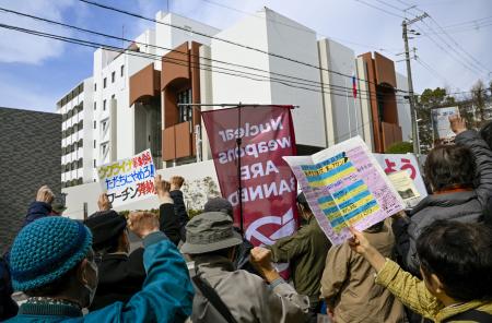 　在大阪ロシア総領事館（奥）の前で、ウクライナ侵攻に抗議する人たち＝２４日午後、大阪府豊中市