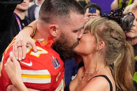 　昨年２月、スーパーボウルの試合を終えたチーフスのトラビス・ケルシー選手（左）とキスするテイラー・スウィフトさん＝米ラスベガス（ＡＰ＝共同）