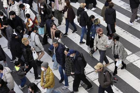 　大阪・梅田の交差点を行き交う人たち＝昨年１２月