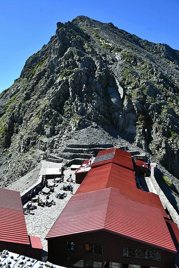 北アルプスの稜線上に立つ穂高岳山荘。奥は奥穂高岳＝今月１１日、岐阜・長野県境