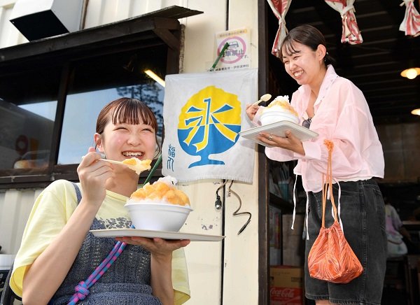 屋外で冷たいかき氷を頬張る女性客＝１７日午後３時５９分、岐阜市伊奈波通、福丸