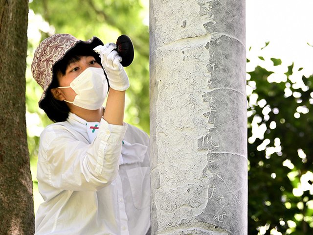 松尾芭蕉の句碑の拓本を取る三枝愛さん。筆跡や傷が浮かび上がっている＝岐阜市伊奈波通