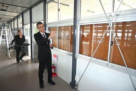 　石川県立輪島高の仮設校舎内で話す高橋潤哉教頭＝４日午後、輪島市