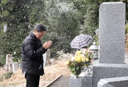 　スキーツアーバス転落事故で亡くなった次男・寛さんの墓に手を合わせる遺族会代表の田原義則さん＝１１日午後、京都府舞鶴市
