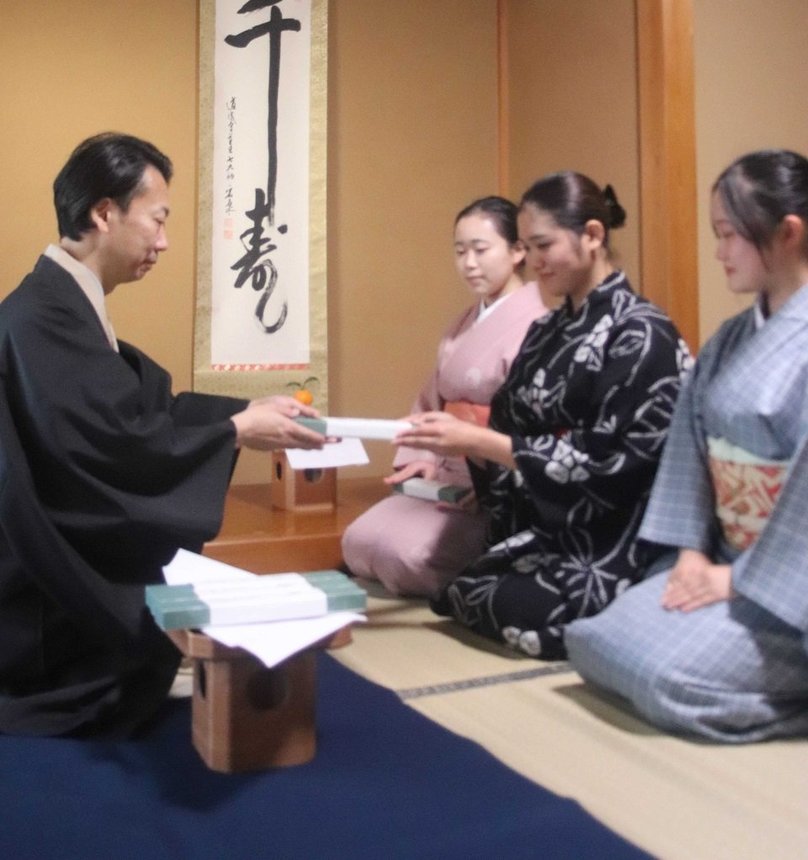 喜久次代表から扇子を受け取る（右から）細井結菜さん、林伊織さん、島田妃那さん＝岐阜市東高岩町、鳳川伎連稽古場