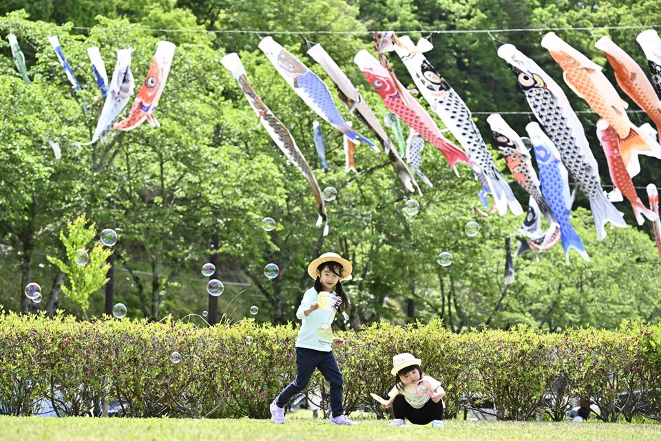 こいのぼりが泳ぐ広場で遊ぶ子どもたち＝４日午前１０時５０分、瑞浪市明世町、瑞浪市民公園