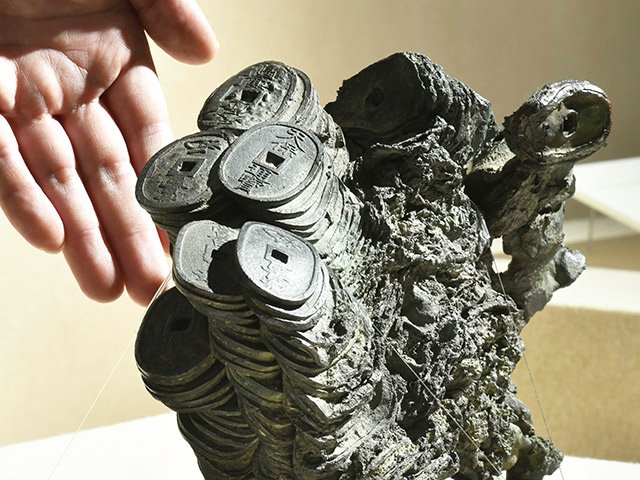 濃尾地震に伴う火災で溶けて固まった天保通宝の塊＝２６日、関市小屋名、県博物館