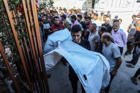 　２８日、ガザ南部ハンユニスで、イスラエル軍の攻撃により親族が殺害されて嘆く人たち（ゲッティ＝共同）