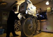 稼働中の３５ミリフィルムの映写機。大きさ１メートルほどのリールが回転している＝岐阜市日ノ出町、ロイヤル劇場