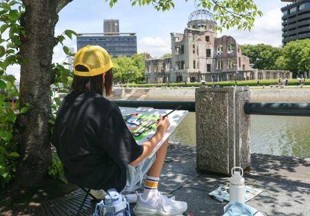 　広島市の平和記念公園で開かれた写生大会で、原爆ドームを描く浅井希光さん＝１９日午前