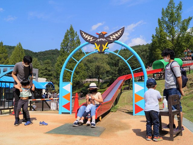 園内に設けられた手指消毒を利用しながら滑り台で遊ぶ家族連れ＝２３日午後、岐阜市山県北野、岐阜ファミリーパーク